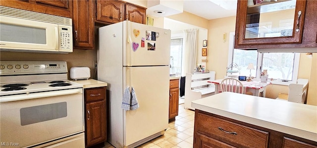 kitchen with white appliances and light tile patterned flooring