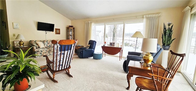 sitting room with lofted ceiling, light carpet, and a wealth of natural light