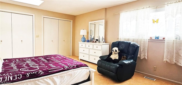 carpeted bedroom featuring two closets