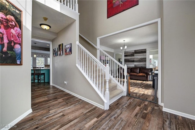 staircase with crown molding and wood-type flooring