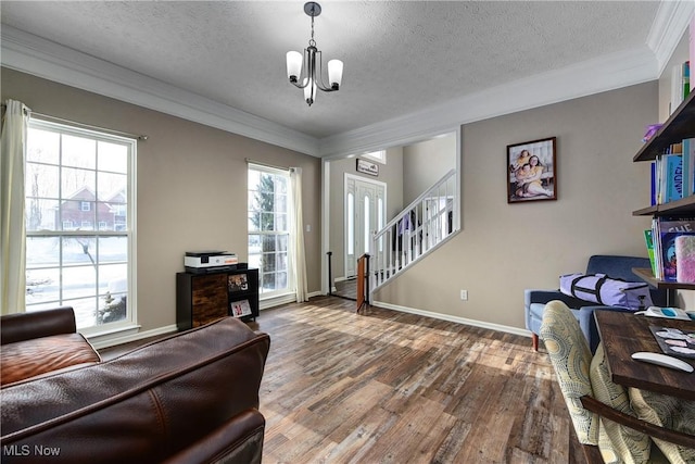 living room with crown molding, a notable chandelier, hardwood / wood-style flooring, and a textured ceiling