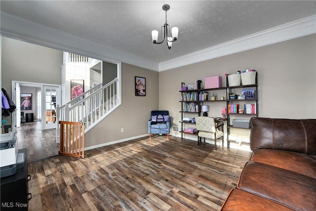 living room featuring a notable chandelier, crown molding, dark wood-type flooring, and a textured ceiling