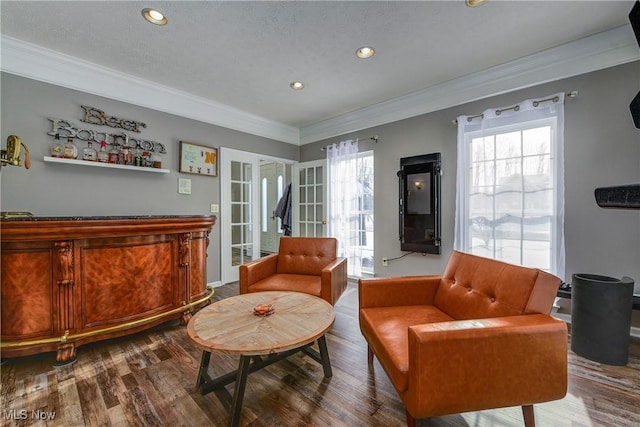 sitting room with plenty of natural light, ornamental molding, french doors, and wood-type flooring