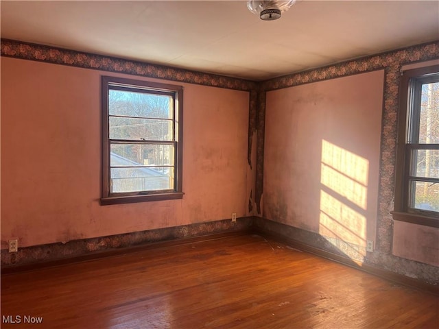 unfurnished room with plenty of natural light and hardwood / wood-style floors