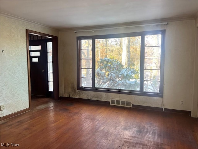 empty room with dark wood-type flooring and ornamental molding