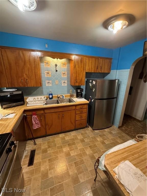 kitchen featuring appliances with stainless steel finishes, sink, and backsplash