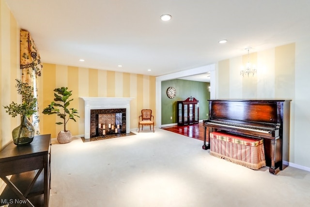 miscellaneous room featuring an inviting chandelier, a fireplace, and carpet