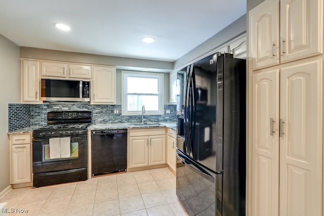 kitchen with light stone counters, sink, black appliances, and light tile patterned flooring