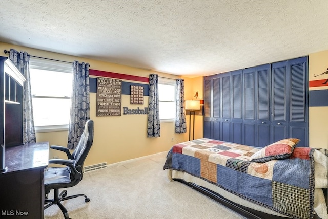 carpeted bedroom featuring a textured ceiling