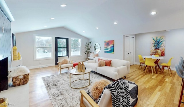 living room featuring vaulted ceiling and light wood-type flooring