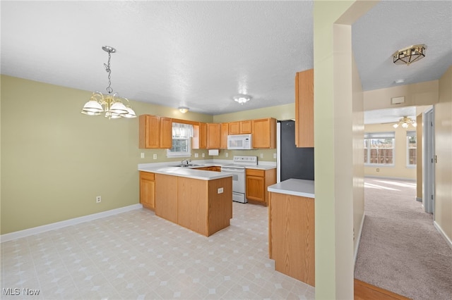 kitchen featuring hanging light fixtures, light colored carpet, white appliances, kitchen peninsula, and a textured ceiling