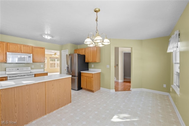 kitchen with hanging light fixtures, white appliances, and a chandelier