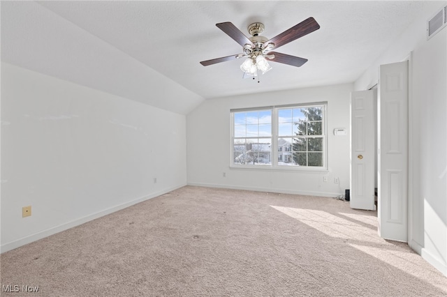 interior space featuring light carpet, vaulted ceiling, and ceiling fan