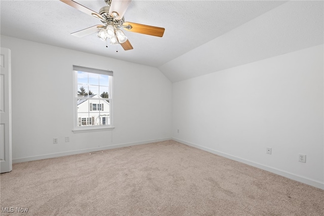 additional living space with lofted ceiling, a textured ceiling, carpet floors, and ceiling fan