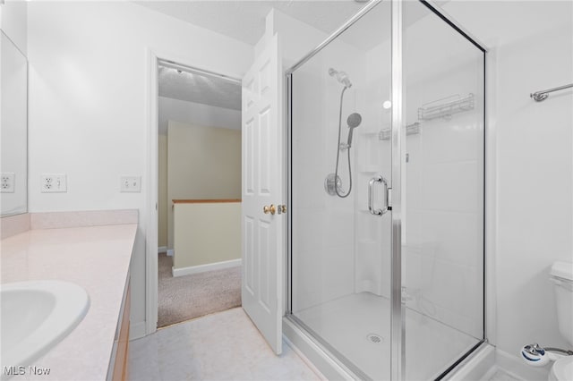 bathroom with vanity, toilet, a textured ceiling, and walk in shower