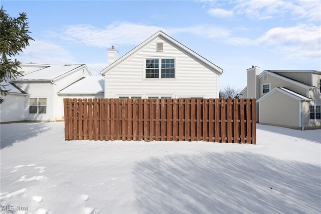 view of snow covered rear of property