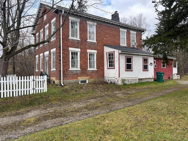 view of side of property featuring cooling unit and a yard