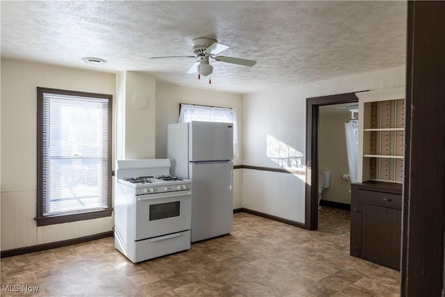 kitchen with ceiling fan, dark brown cabinets, a textured ceiling, and white appliances