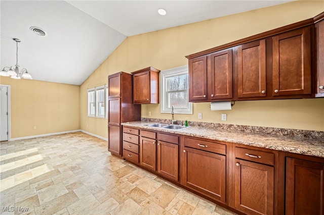 kitchen featuring pendant lighting, sink, lofted ceiling, and an inviting chandelier