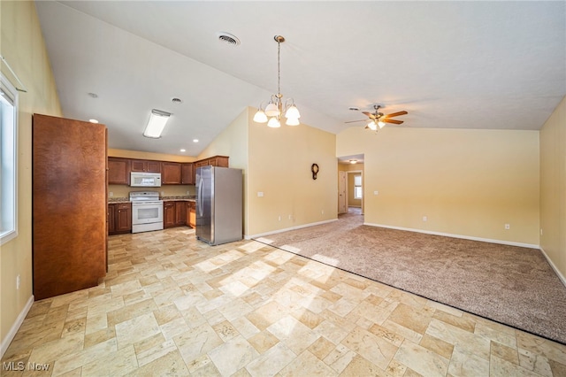 kitchen featuring hanging light fixtures, lofted ceiling, plenty of natural light, and white appliances