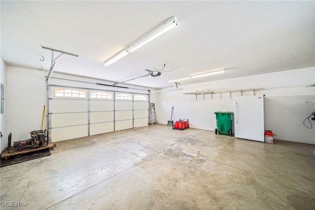 garage with white refrigerator and a garage door opener