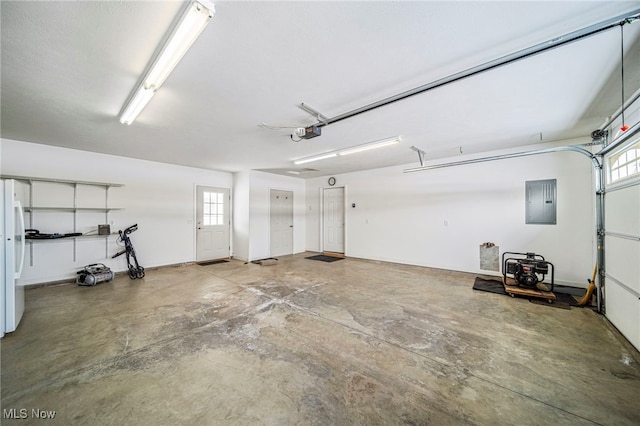 garage with a garage door opener, electric panel, and white refrigerator