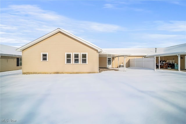 view of snow covered rear of property