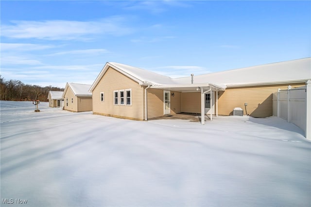 view of snow covered back of property