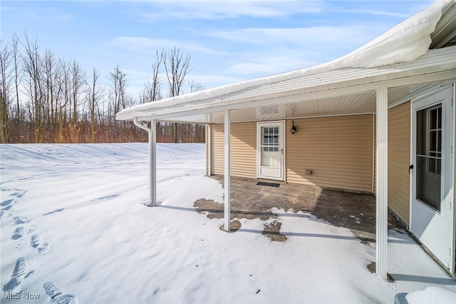 snow covered patio with a carport