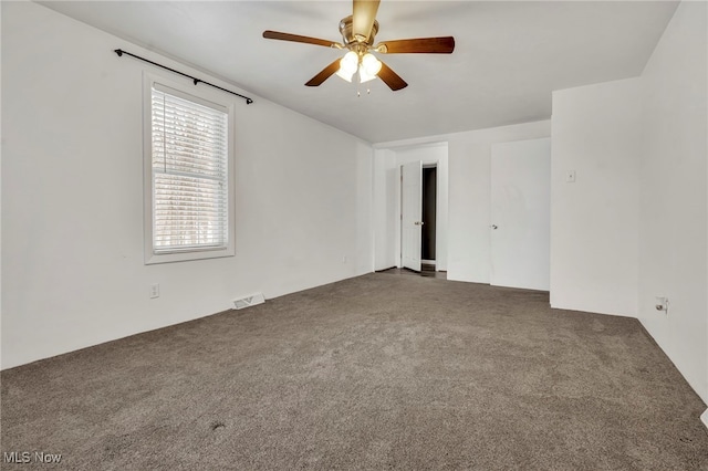 empty room with dark carpet and ceiling fan