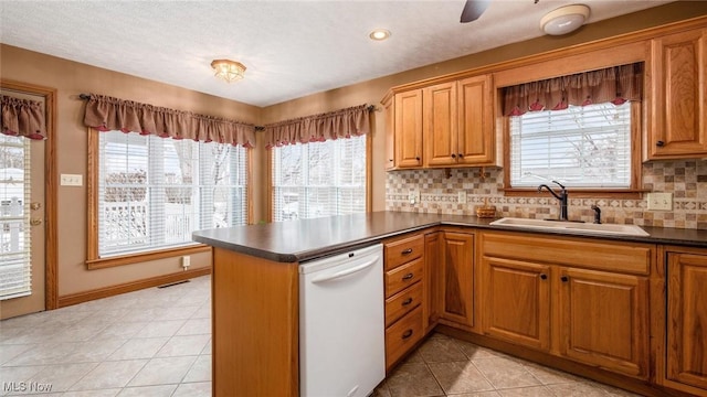 kitchen with dishwasher, sink, decorative backsplash, light tile patterned floors, and kitchen peninsula