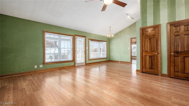 interior space with ceiling fan with notable chandelier, lofted ceiling, and light hardwood / wood-style floors