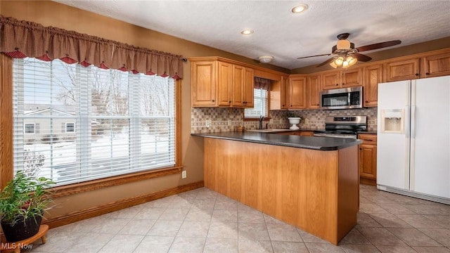 kitchen featuring sink, a wealth of natural light, stainless steel appliances, and kitchen peninsula