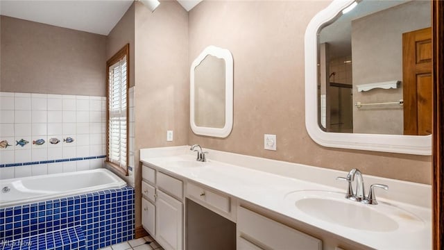 bathroom featuring vanity, tiled bath, and tile patterned flooring