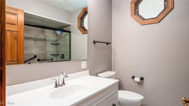 bathroom featuring toilet, vanity, and walk in shower