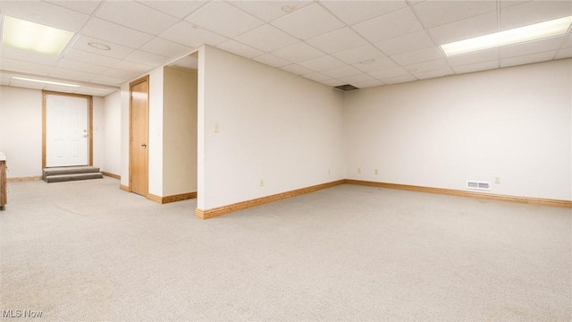 basement featuring a drop ceiling and carpet floors