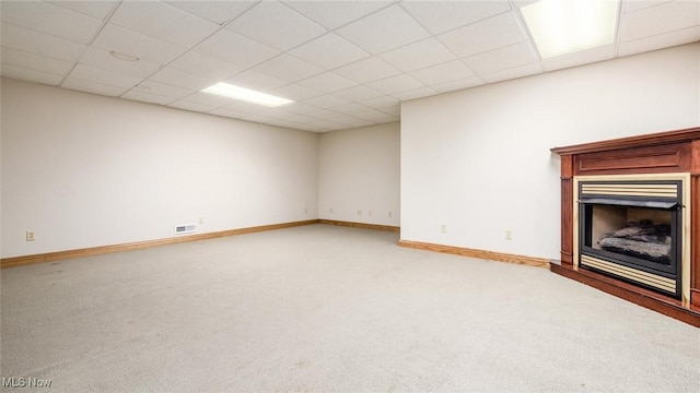 unfurnished living room with carpet and a drop ceiling