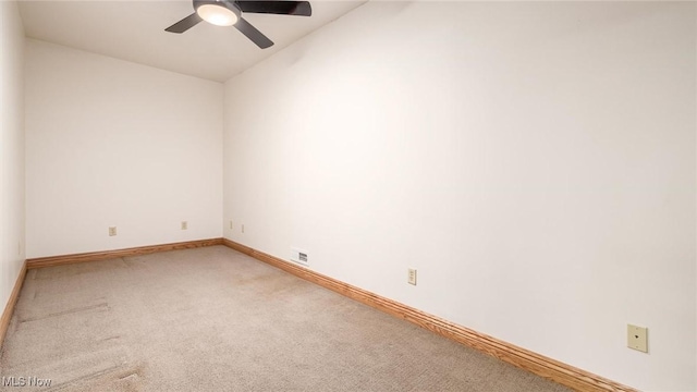 carpeted spare room featuring lofted ceiling and ceiling fan