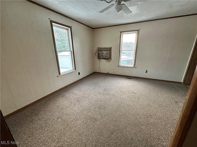 carpeted spare room featuring crown molding, a wall mounted AC, and ceiling fan