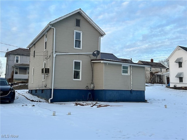 view of snow covered back of property