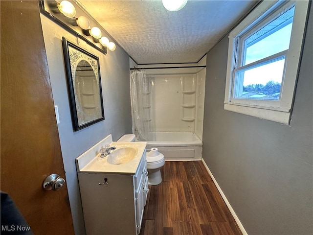 full bathroom featuring shower / tub combo with curtain, wood-type flooring, vanity, toilet, and a textured ceiling