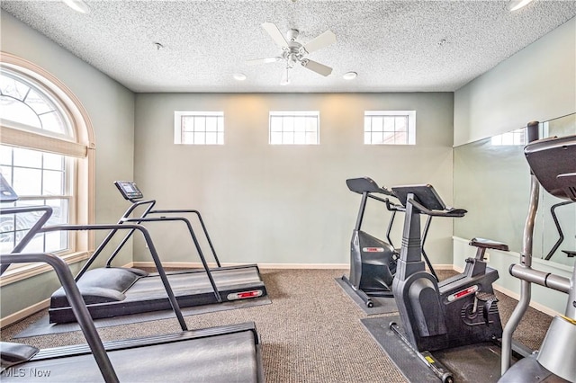 workout area featuring ceiling fan, carpet flooring, and a textured ceiling