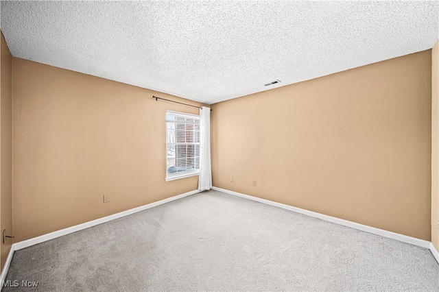 unfurnished room with carpet flooring and a textured ceiling