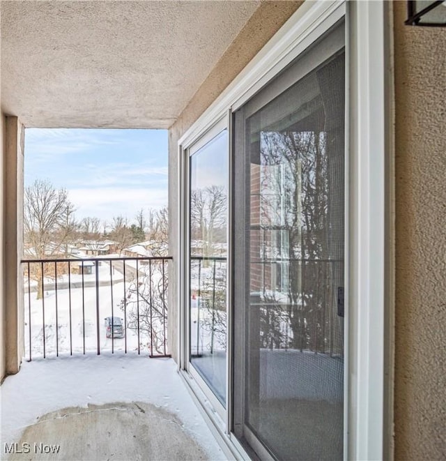 view of snow covered back of property