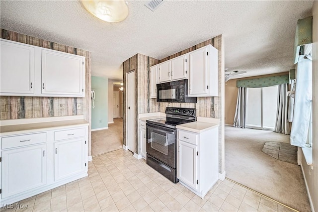 kitchen featuring white cabinetry, light colored carpet, black appliances, and a textured ceiling