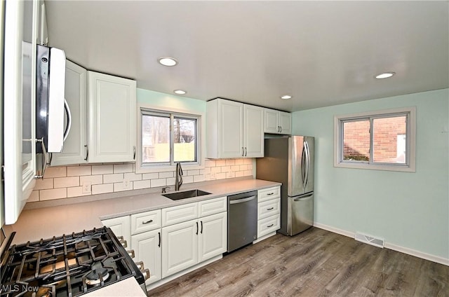 kitchen with stainless steel appliances, sink, and white cabinets