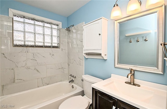 full bathroom featuring vanity, tiled shower / bath combo, and toilet