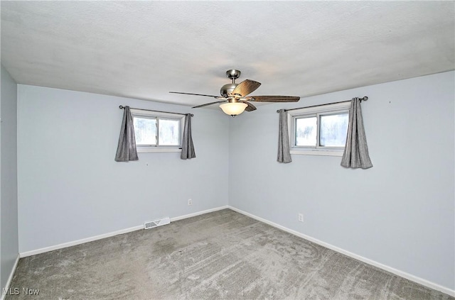 carpeted spare room with ceiling fan and a textured ceiling