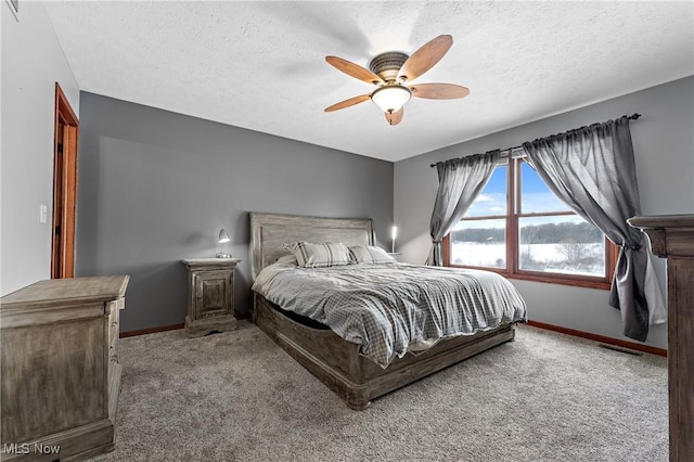 carpeted bedroom featuring a textured ceiling and ceiling fan