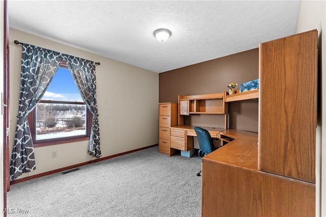 home office featuring carpet floors and a textured ceiling